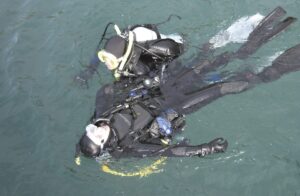 Dwóch nurków ćwiczących udzielanie pierwszej pomocy i ratownictwo na powierzchni wody podczas kursu Junior Rescue Diver
